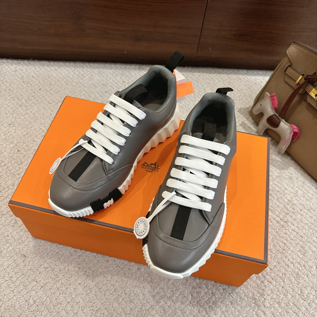 Hermes gray low-top sneakers, white laces, black insets, and white rugged sole