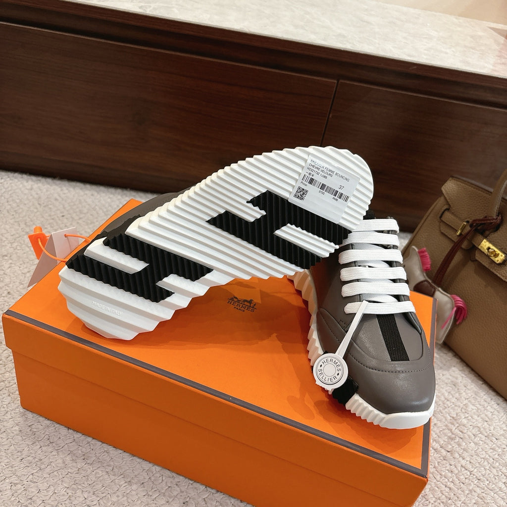 Hermes gray sneaker outsole view with white tread and side black stripe