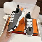 Hermes gray sneakers with white laces and black stripe detail; thick white tread sole