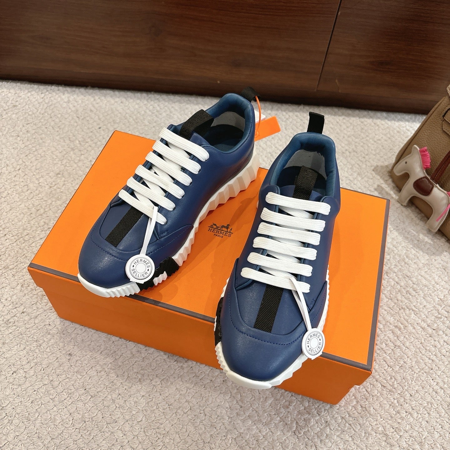 Blue lace-up sneakers with white laces, cushioned sole, and circular side emblem