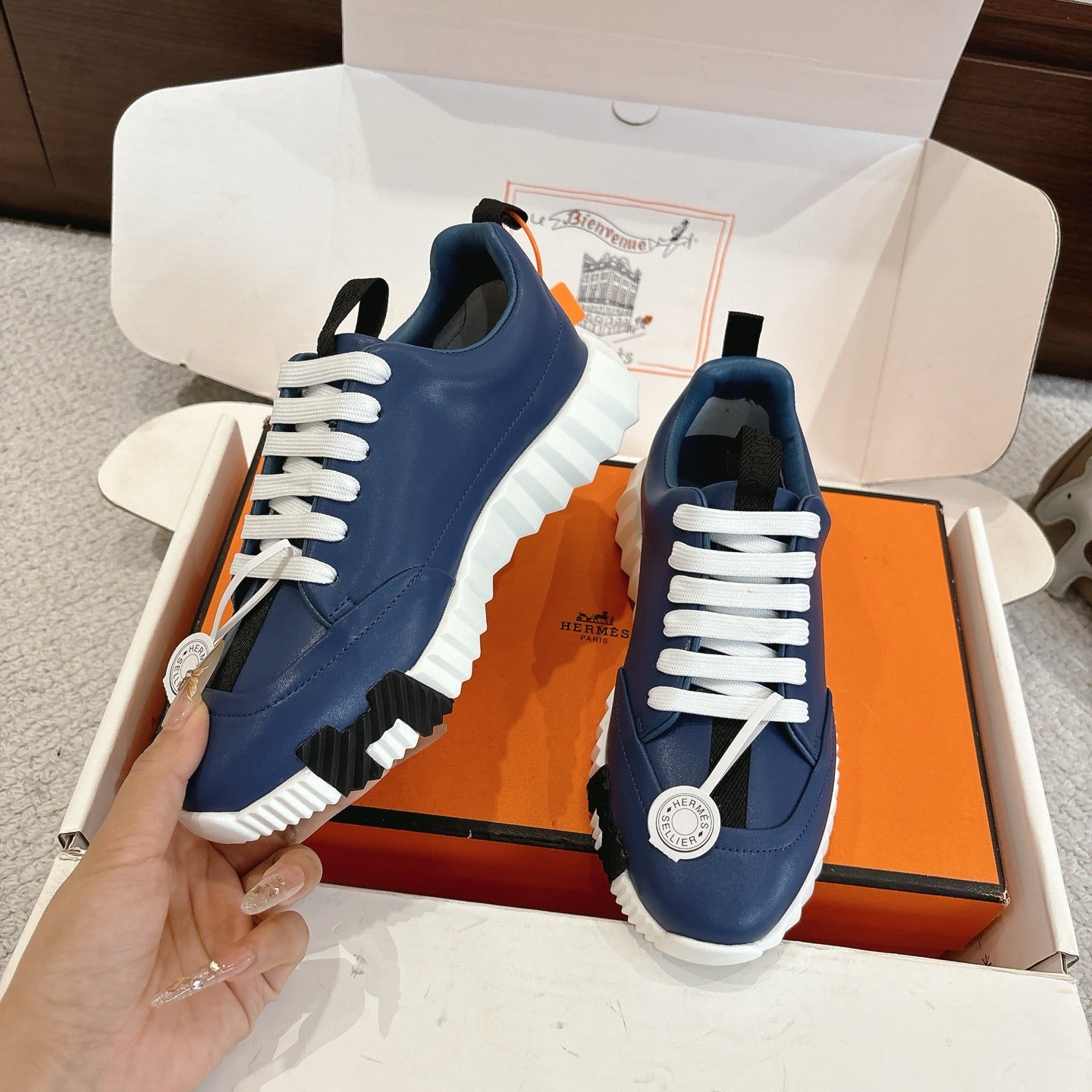 Pair of blue sneakers with white laces, white midsole, and side logo badge