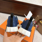 Back view of blue sneakers with white outsole and black heel strap detail