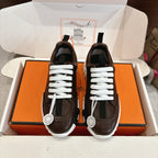 Hermes unisex luxury shoes, dark brown leather, white laces, front view on box