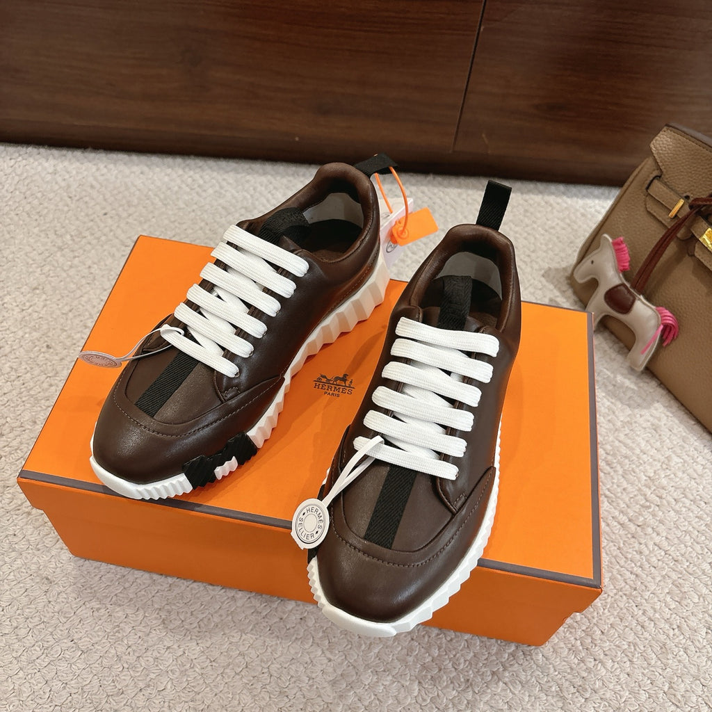Hermes unisex luxury shoes, dark brown leather, white laces, pair angled on box
