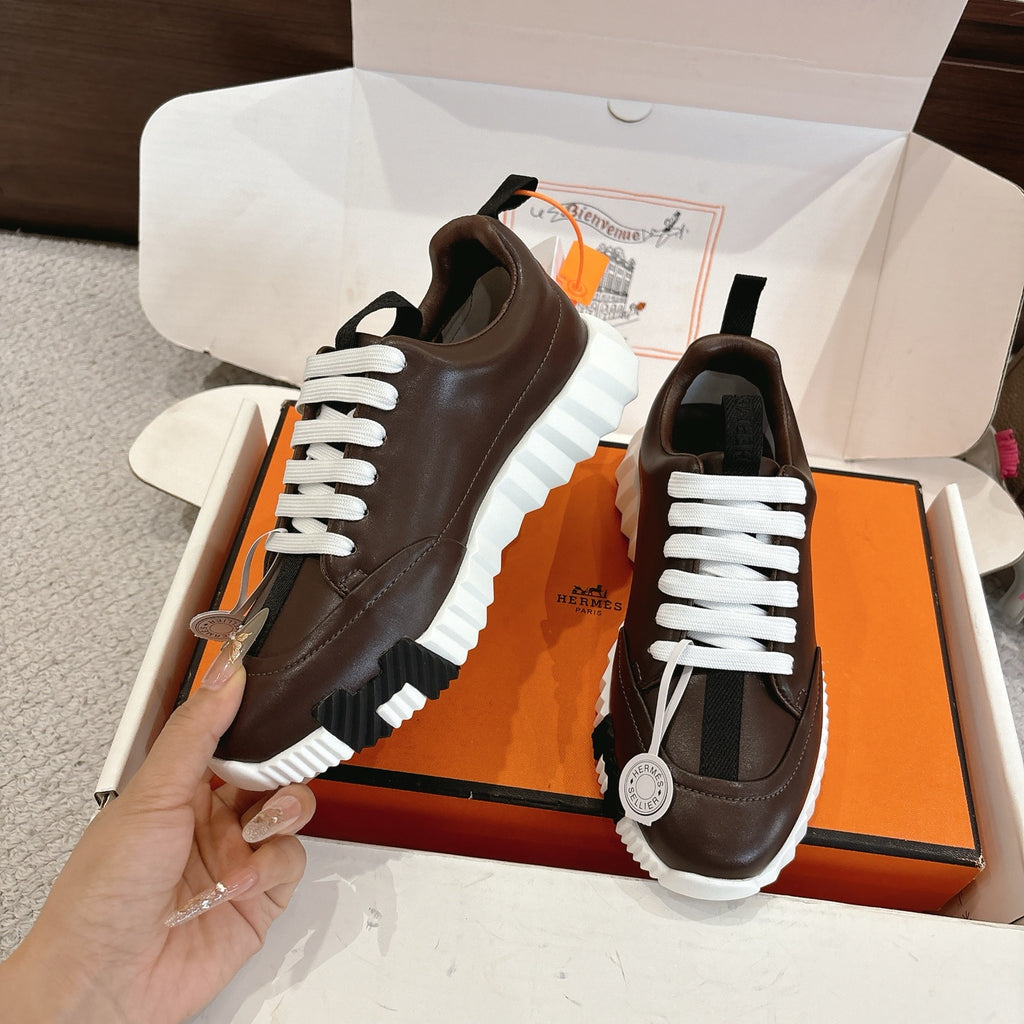 Hermes unisex luxury shoes, dark brown leather, white laces, side view on box