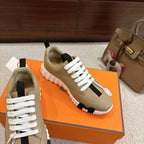 Beige unisex sneakers with white laces, black heel tab, and chunky white rubber sole.