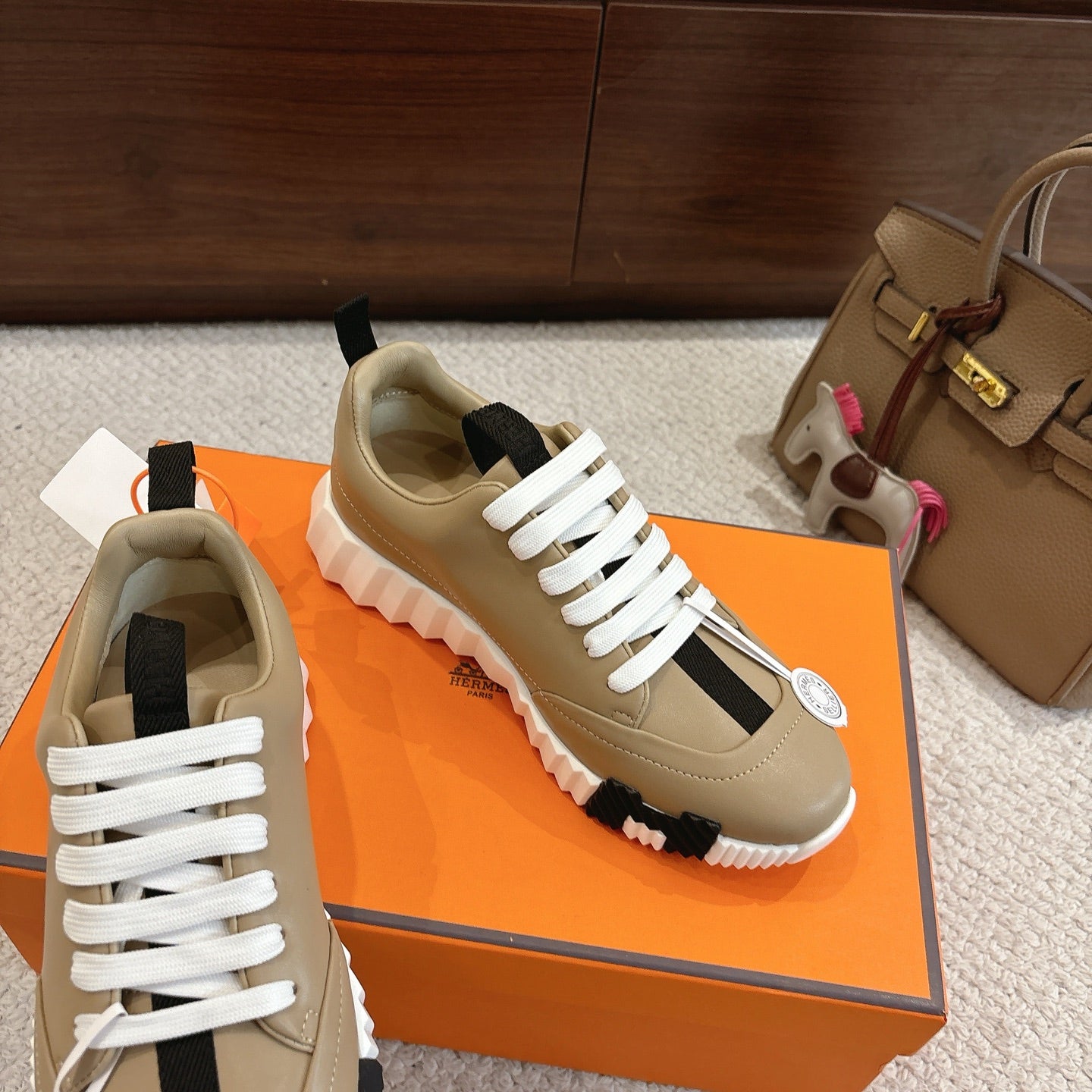 Beige unisex sneakers with white laces, black heel tab, and chunky white rubber sole.