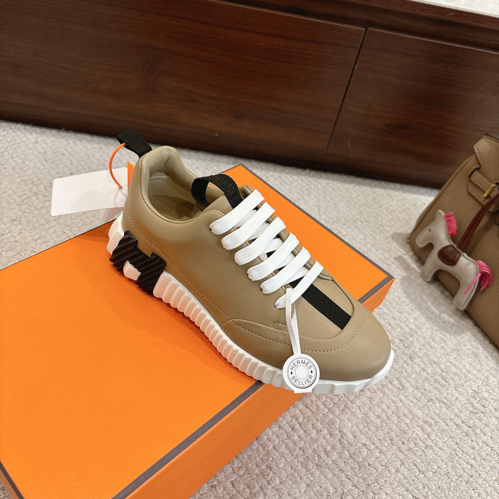 Beige unisex low-top sneakers with white laces and black stripe, featuring thick white outsole.
