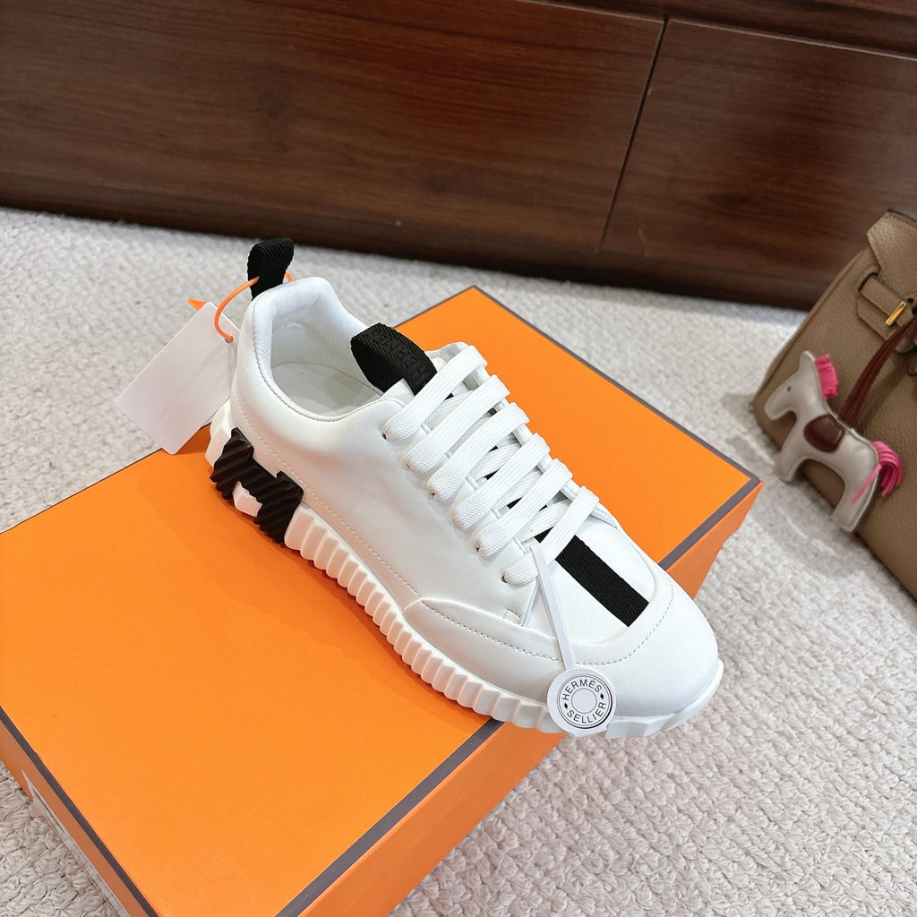 White Hermes lace-up sneakers with black trim and thick ridged sole, side view.
