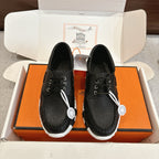 Black leather lace-up shoes with white textured sole and metal lace tips, pair view.