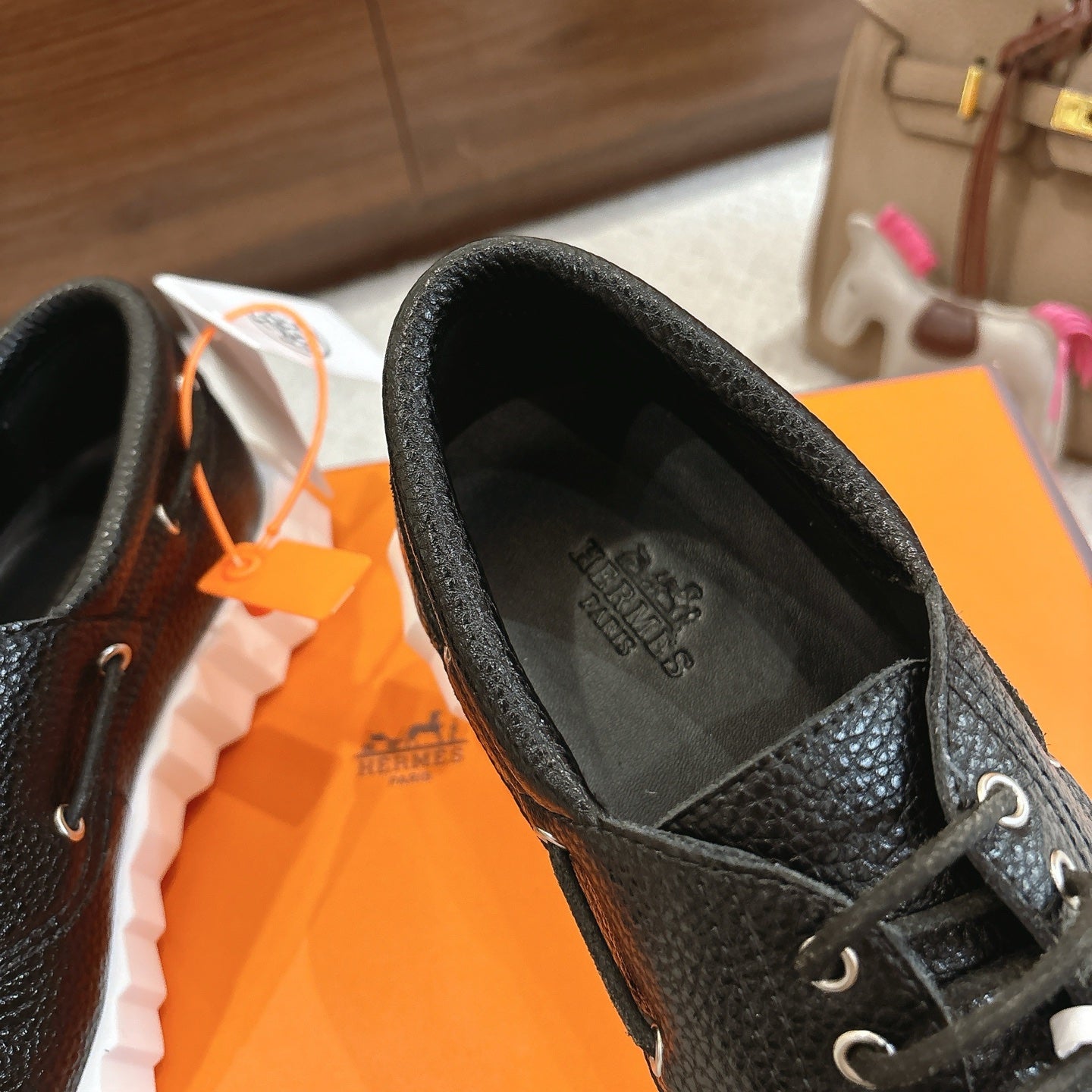 Black leather lace-up shoe interior view with printed logo and lace-up front.