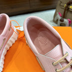 Pink leather sneaker close-up, open collar interior and lace-up panel detail.