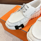 White leather sneaker close-up with lace hardware and ribbed sole tread