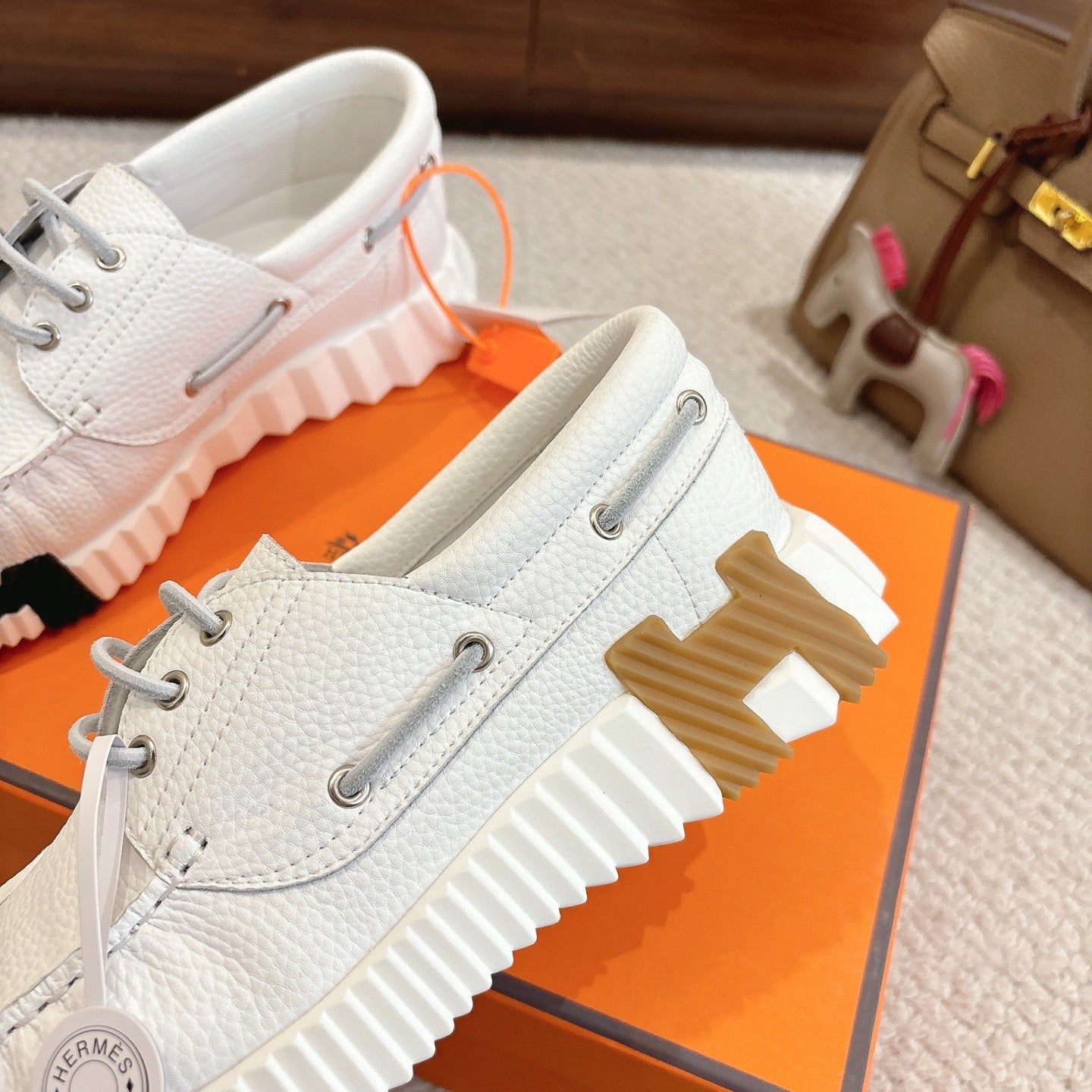 White leather sneakers with ribbed side panels and gray lace-up front