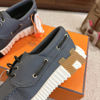 Blue leather lace-up sneaker with thick white tread and white-striped sole detail