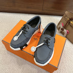 Blue leather unisex lace-up sneakers with white ridged sole and round logo tag