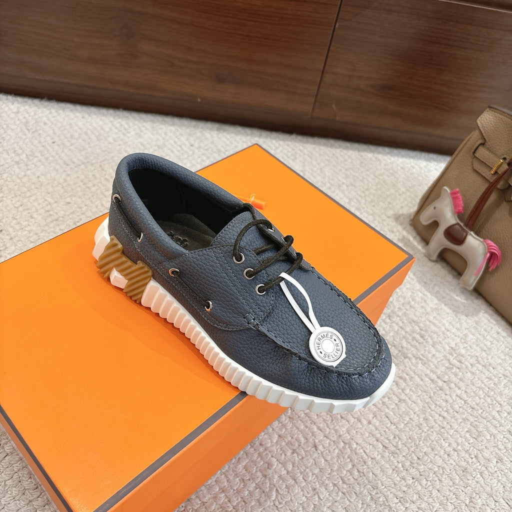 Blue leather lace-up sneakers with white ridged outsole and round logo patch