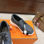 Blue leather lace-up sneakers with white outsole and round charm on the side