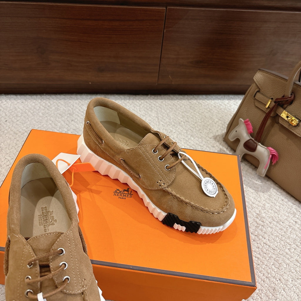 Tan suede lace-up sneaker with white ribbed sole and round logo patch on side