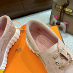 Beige lace-up shoe with pink-lined interior and logo on insole