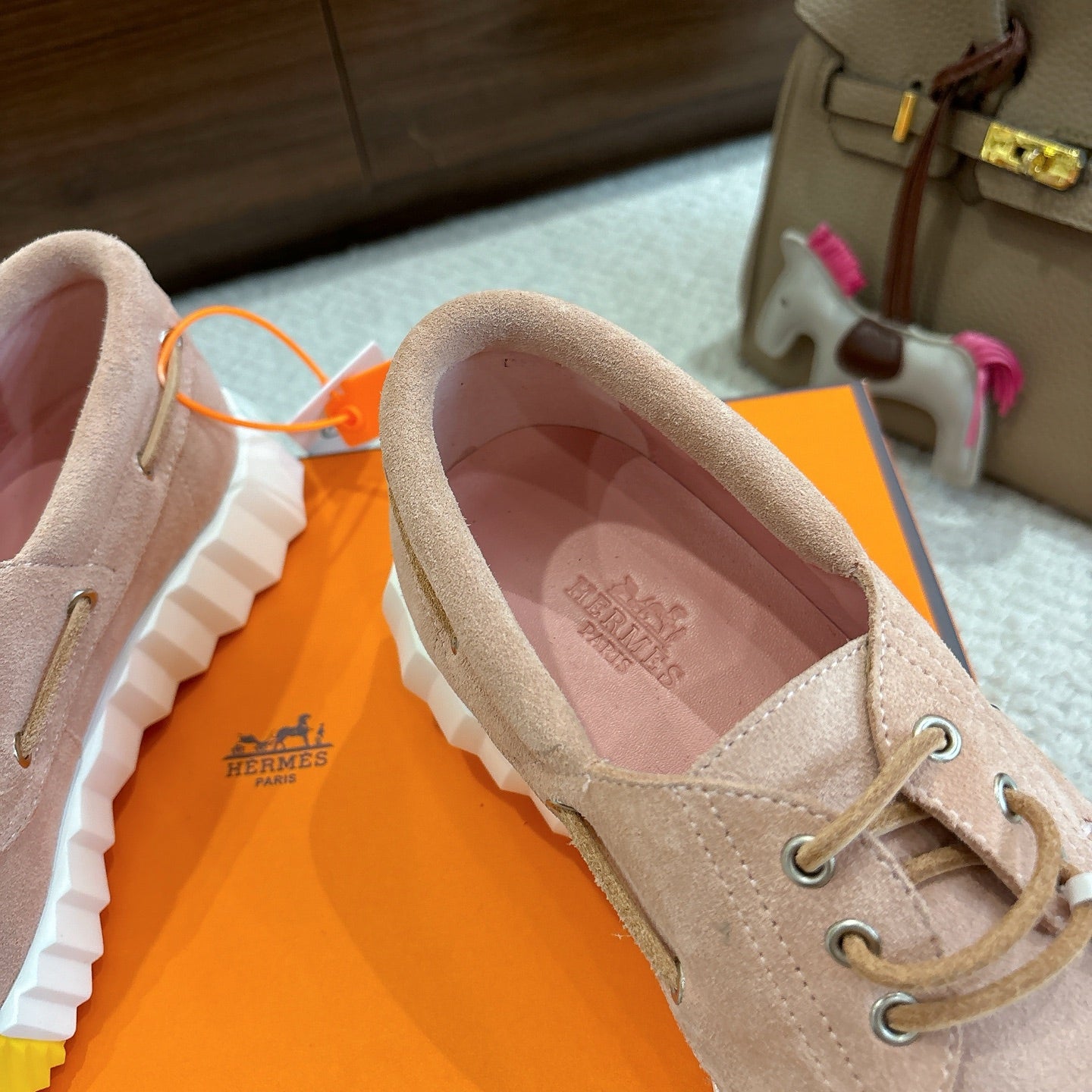 Beige lace-up shoe with pink-lined interior and logo on insole