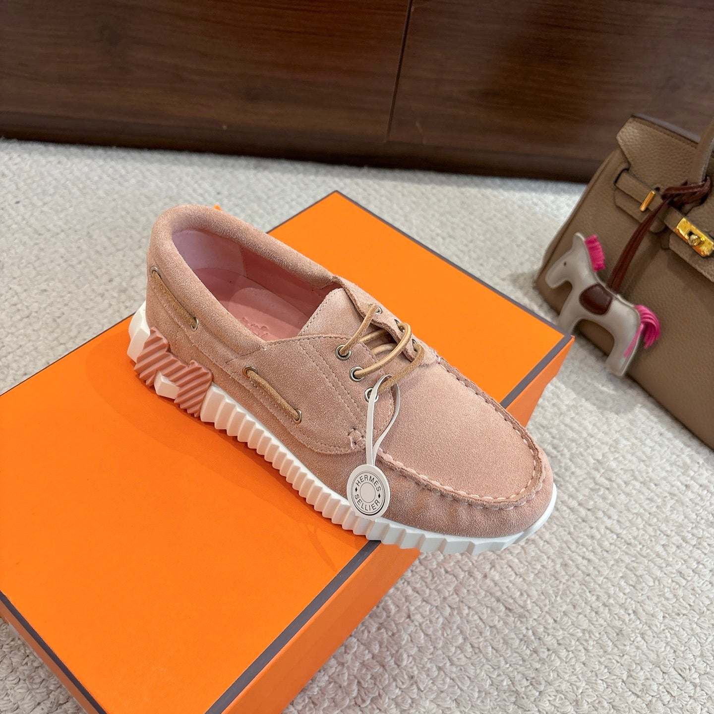 Beige suede lace-up shoes with white ridged outsole and yellow accent tread
