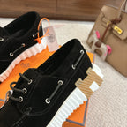 Black lace-up unisex shoes, side view showing white ridged tread