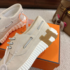 Light beige lace-up sneakers with top pull tab and patterned side tread detail