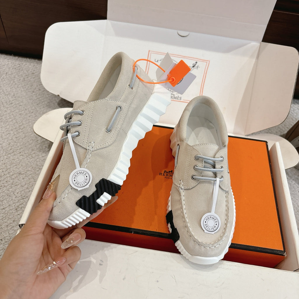 Light beige lace-up sneakers with ribbed sole and circular logo patch on side