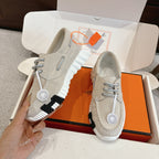 Light beige lace-up sneakers with ribbed sole and circular logo patch on side