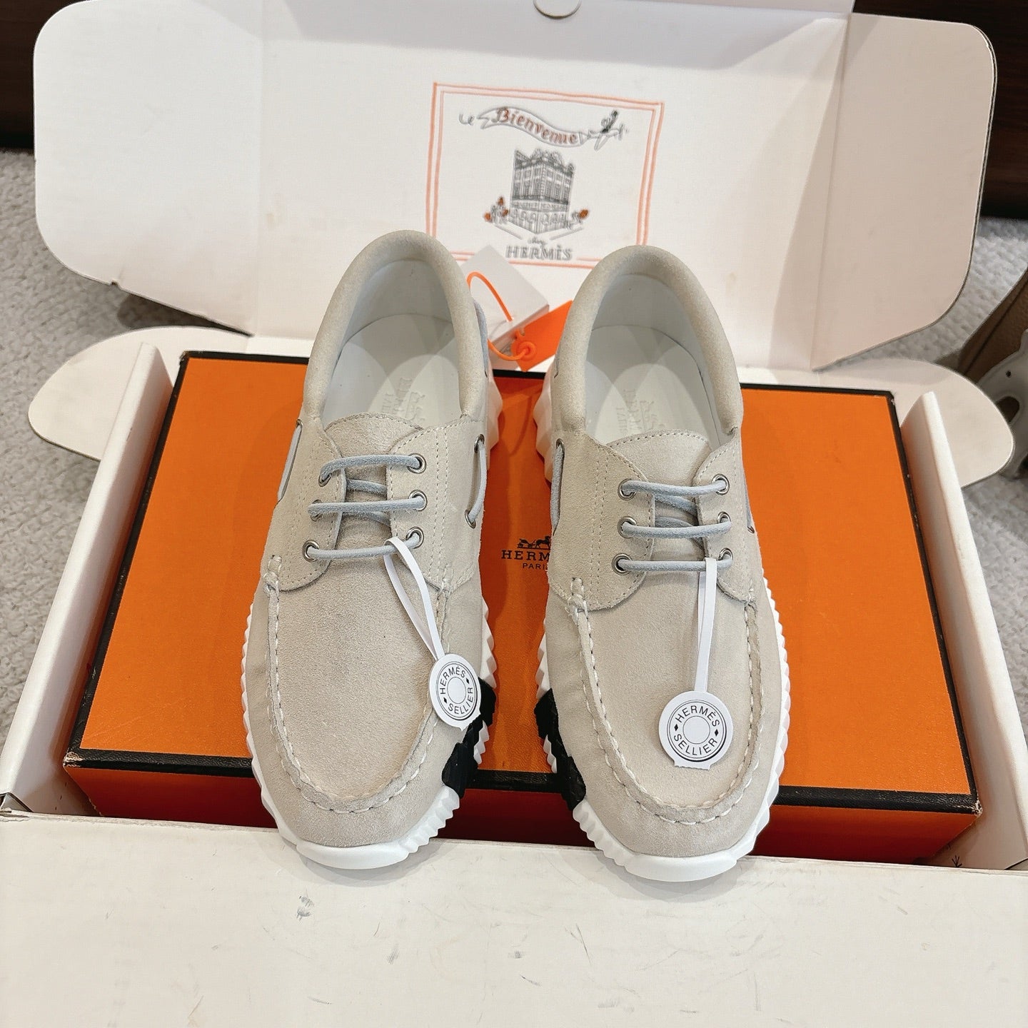 Light beige lace-up shoes with round eyelets and stitched moccasin seams