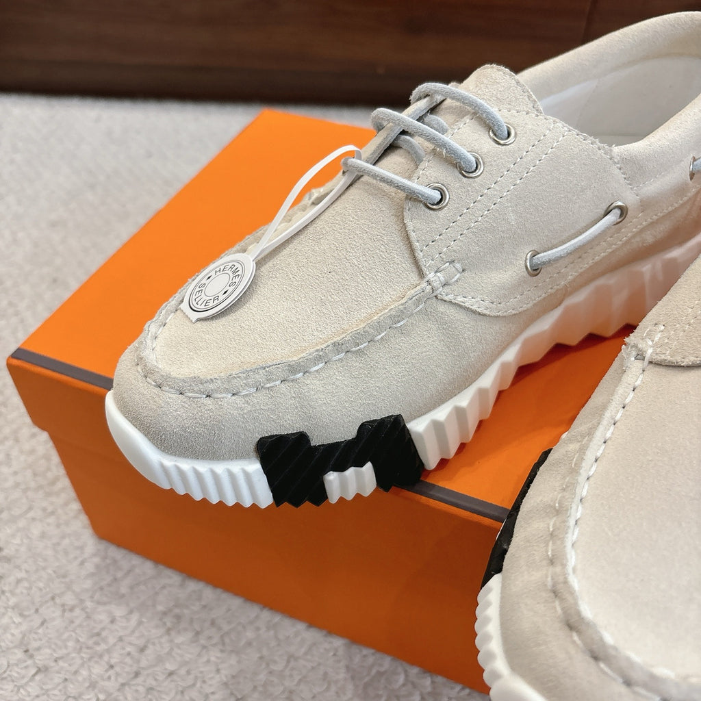 Light beige lace-up shoe close-up with round logo tag and contrast ribbed sole