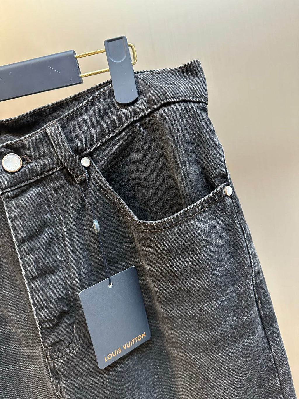 Dark blue denim pants waist detail with front button and pocket openings