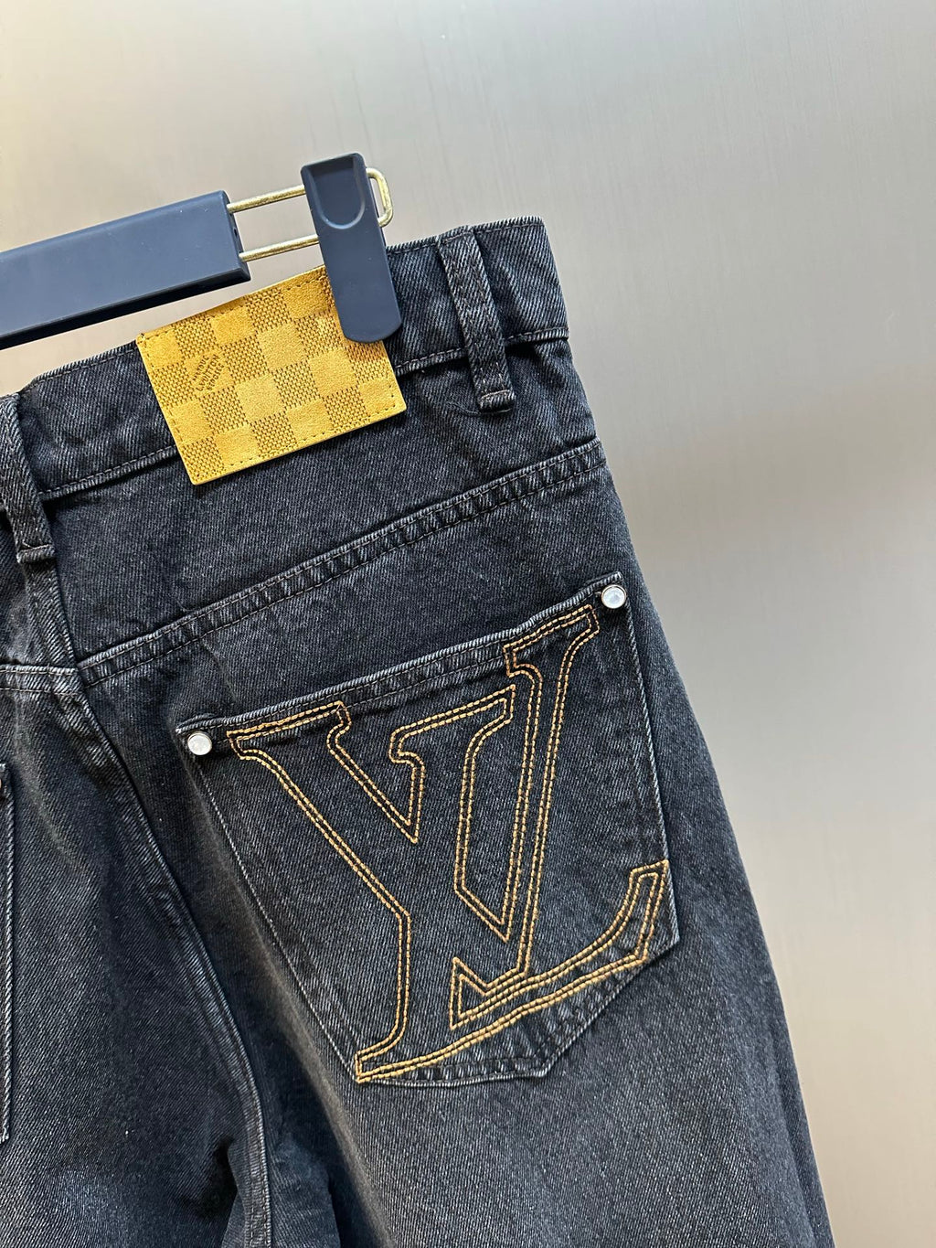 Dark blue denim pants with LV V-pocket logo and gold-tone stitched trim