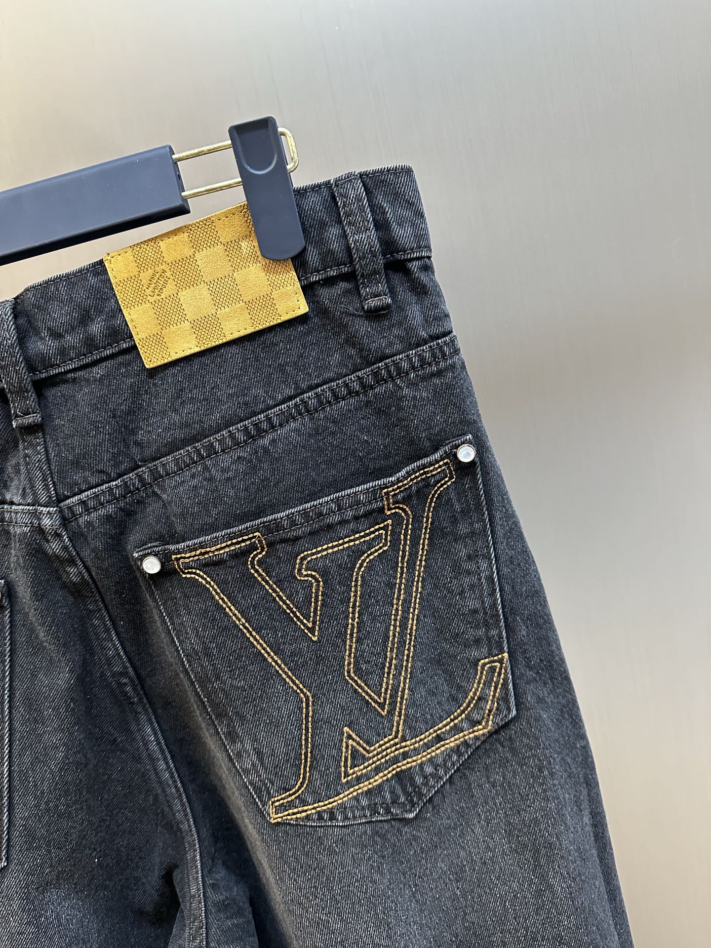 Dark blue denim pants with LV V-pocket logo and gold-tone stitched trim