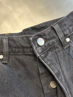Dark blue denim pants waistband with snap buttons and metal hardware