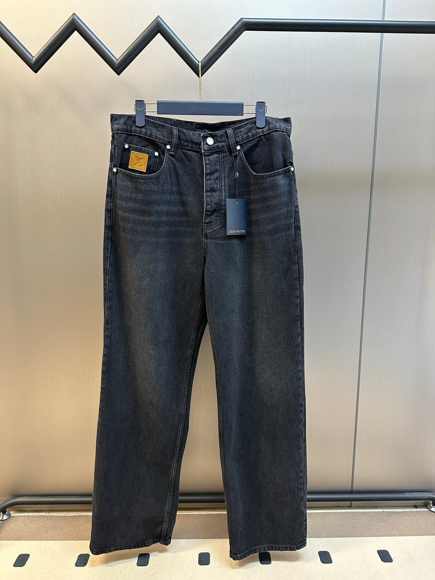 Dark blue denim pants with front button-and-zip closure and belt loops