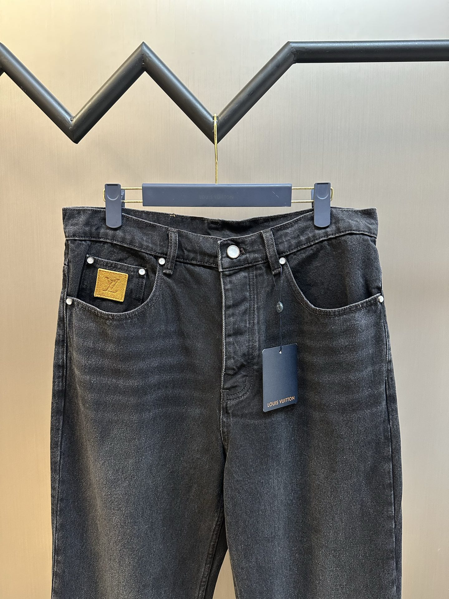 Dark blue denim pants with two front pockets and waistband button closure