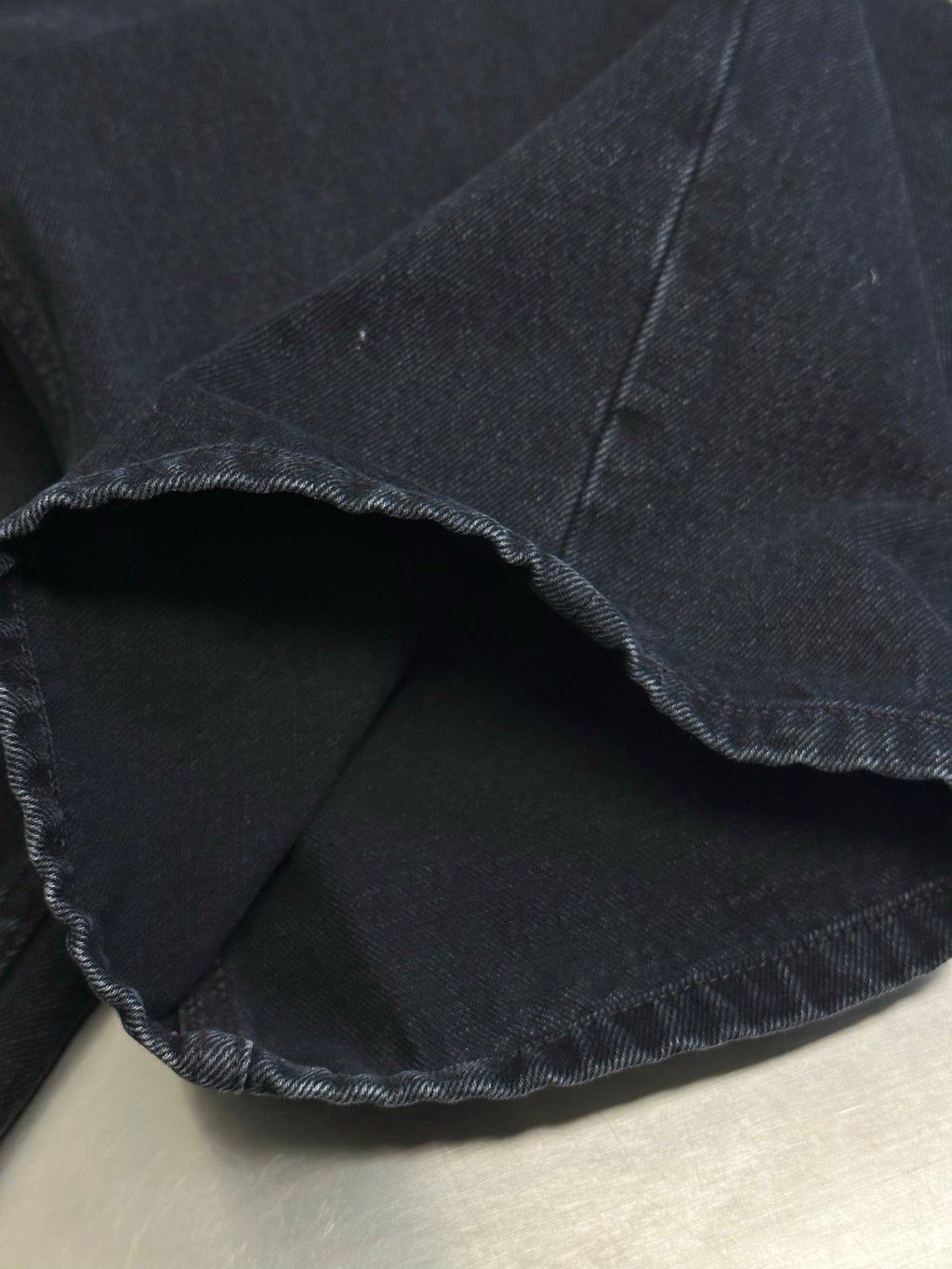Dark blue denim pants fabric panel with stitched inner seam