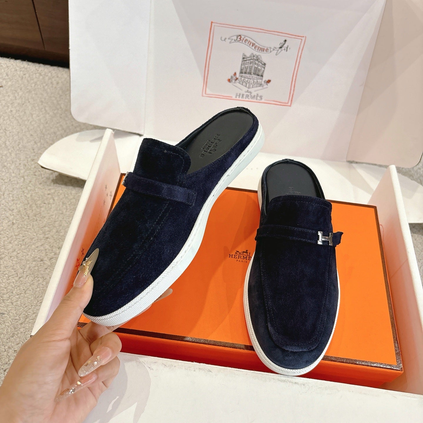 Hermes unisex suede loafers, dark blue slip-on style with H buckle and white outsole.