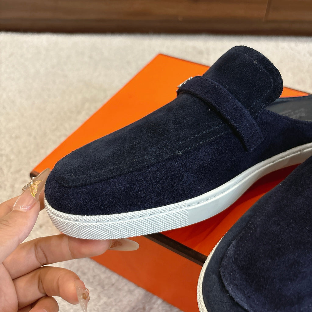 Hermes unisex suede loafer in dark blue with thick rubber sole and front strap.