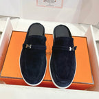 Hermes unisex suede loafers in dark blue with metal H buckle and white rubber sole.