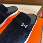 Hermes unisex loafer close-up: dark blue suede with silver-tone H buckle on strap.