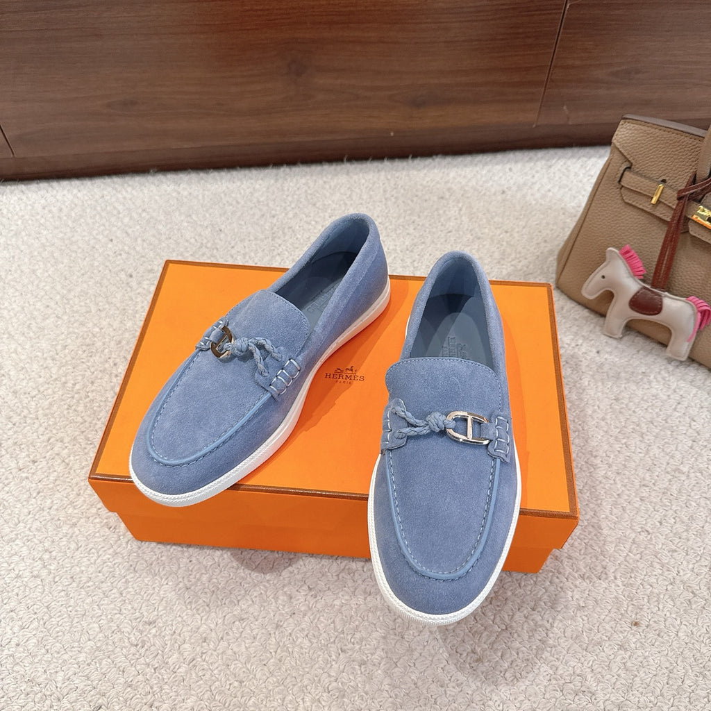 Blue suede slip-on loafers with metal buckle strap and white sole