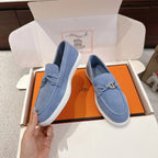Light blue suede loafers with metal buckle strap, viewed from side