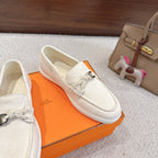 Hermes unisex white suede loafers, angled side view with metal horsebit and laced top