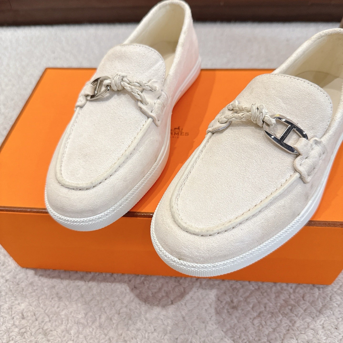 Hermes unisex white suede loafers, close-up front with metal horsebit and braided cord