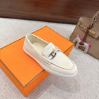 Hermes unisex white suede loafers, front view with metal horsebit and braided lace