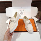 Hermes unisex white suede loafers, side view with metal horsebit and braided tassel