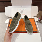 Hermes suede loafers, dark olive green with braided laces and metal bit; front view